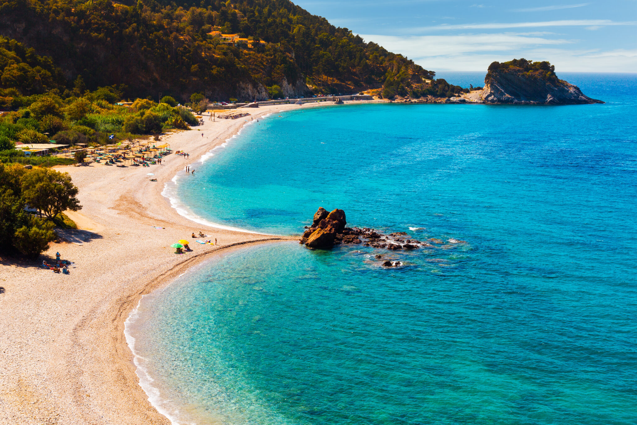 Potami Beach with beautiful pebbles and the river leading to spectacular waterfalls